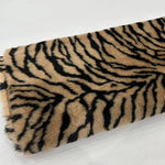 Load image into Gallery viewer, A close-up of a faux fur fabric with a black and tan tiger stripe pattern, shown on a white background with Chinese text in the top-left corner.
